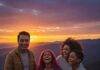 How to Plan the Perfect Family Vacation Without Breaking the Bank A diverse family enjoys a vibrant sunset view, laughing together.