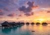 Top 10 Best Beach Resorts for an Unforgettable Getaway in 2025 Luxurious overwater villas at sunset.